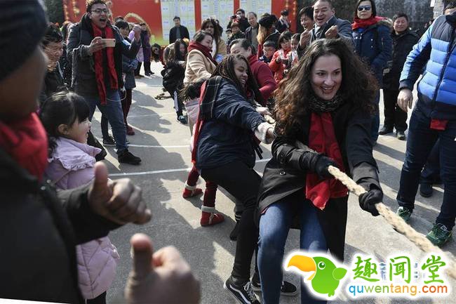 2月4日，外国友人在鸣雁村与村民一起进行拔河比赛。春节临近，近100位外国友人应邀来到浙江省宁波市奉化区尚田镇鸣雁村，体验舞龙、写春联、打年糕、剪窗花等传统民俗活动，迎接新春佳节。   新华社记者 黄宗治 摄