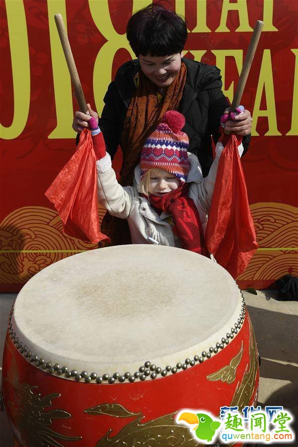2月4日，来自乌兹别克斯坦的阿纳斯塔西娅（前）在体验敲鼓。春节临近，近100位外国友人应邀来到浙江省宁波市奉化区尚田镇鸣雁村，体验舞龙、写春联、打年糕、剪窗花等传统民俗活动，迎接新春佳节。   新华社记者 黄宗治 摄